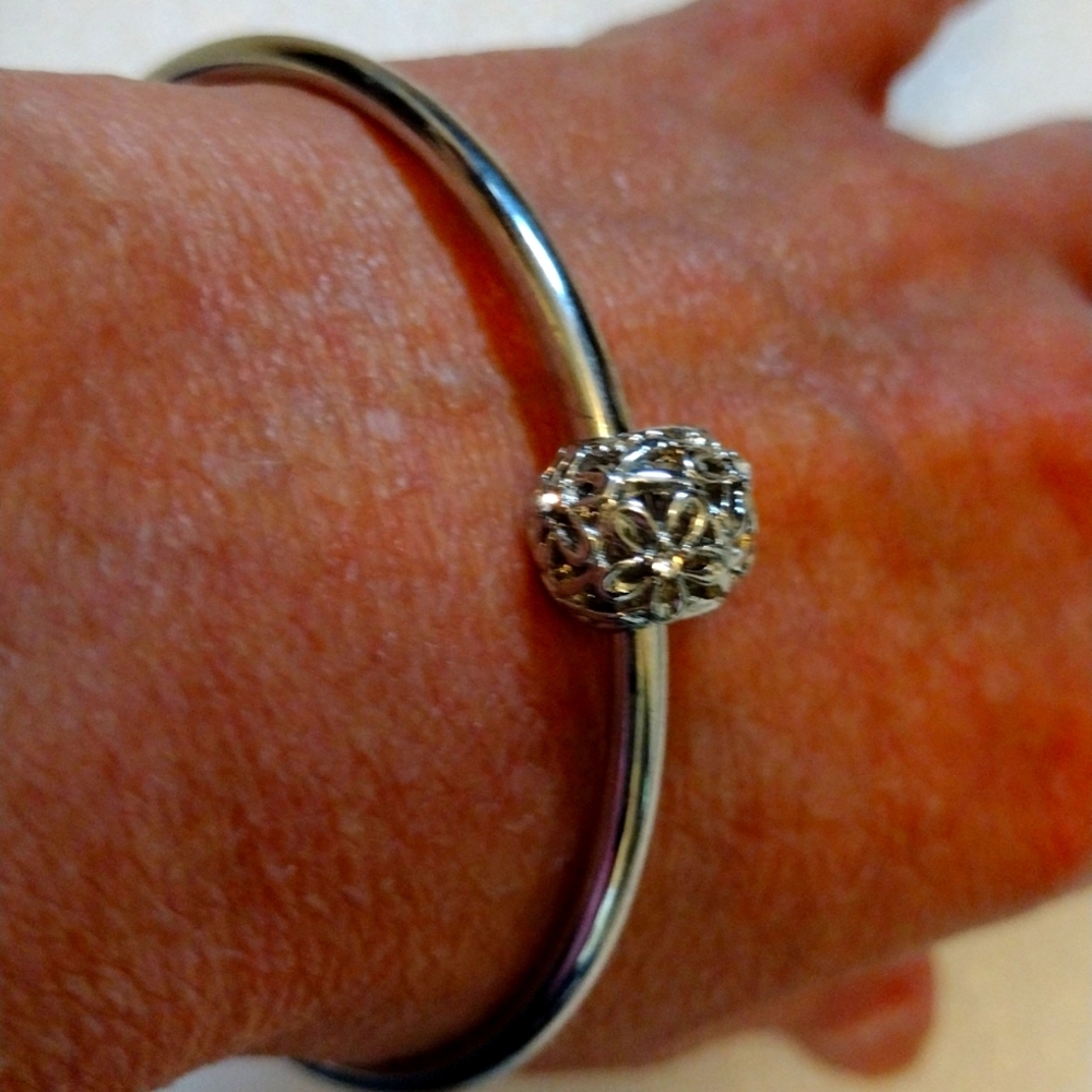 Beautiful faux silver charms bracelet with faux silver and rhinestones floating.